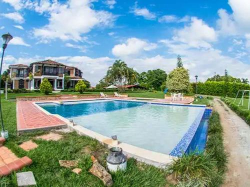 a swimming pool in front of a house at Finca Hotel Casa Nostra, Villa Manuela in Quimbaya
