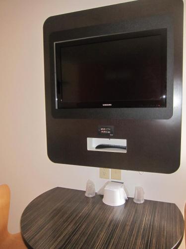a flat screen tv sitting on top of a table at Howard Johnson by Wyndham Lake George in Lake George