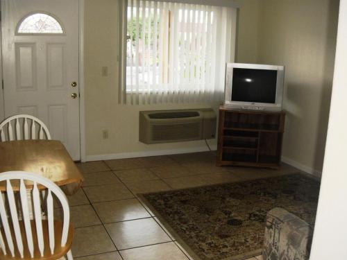 a living room with a tv on a wooden table at Sunrise Motel in Seaside Heights