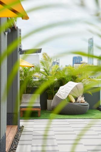 a person laying on a bed on a balcony at Kritthai Residence in Bangkok