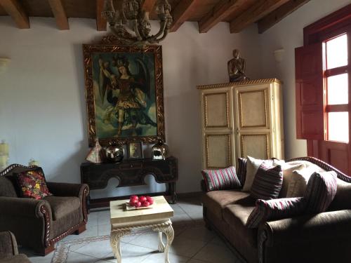 a living room with couches and a painting on the wall at Hotel Mansion Real in San Sebastián del Oeste