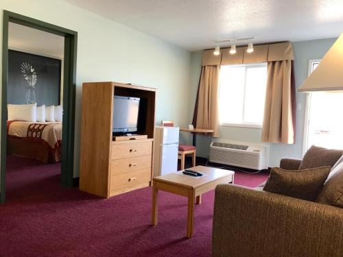 a hotel room with a couch and a tv and a bed at Super 8 by Wyndham Kindersley in Kindersley