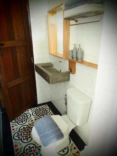 a bathroom with a toilet with a blue mat on the floor at Chernchan Hostel in Chanthaburi