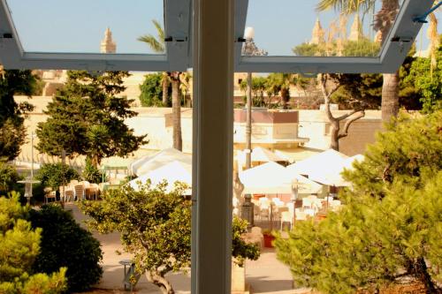 a window view of a patio with tables and umbrellas at Maleth Inn in Rabat