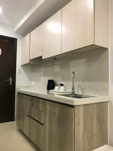 a kitchen with a sink and wooden cabinets at Umali Kayo at Megatower Residences II in Baguio