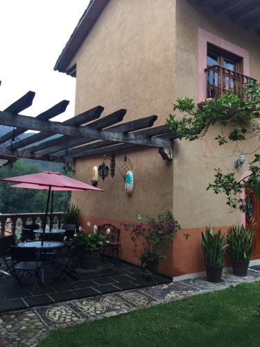 an outdoor patio with a table and an umbrella at Hotel Mansion Real in San Sebastián del Oeste