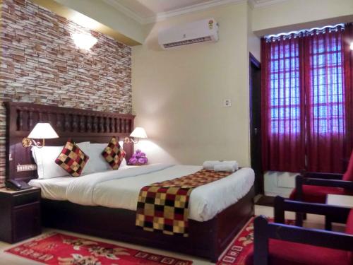 Un dormitorio con una cama y una pared de ladrillo. en Hotel Palace Tower, en Trichūr