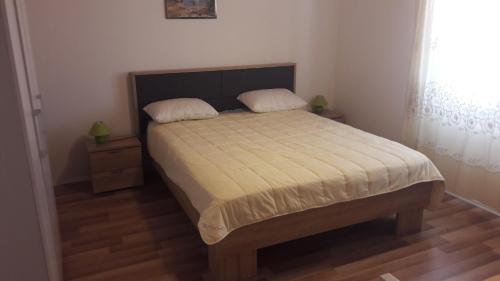 a bedroom with a bed with two pillows on it at Nora Apartments in Povljana