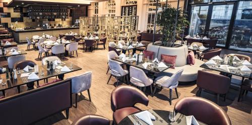 a restaurant with tables and chairs and a bar at SCHLOSS Fleesensee in Göhren-Lebbin