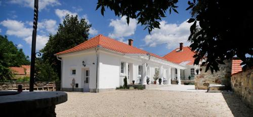 a large white building with a red roof at Vidéki Varázs Vendégház in Bogács