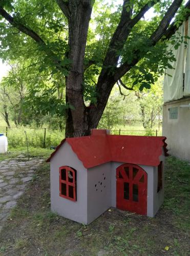 a dog house with a red roof next to a tree at Guest House Iaraji in Tʼianetʼi