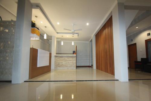 un soggiorno con ventilatore a soffitto e una cucina di Tom Guest House a Legian