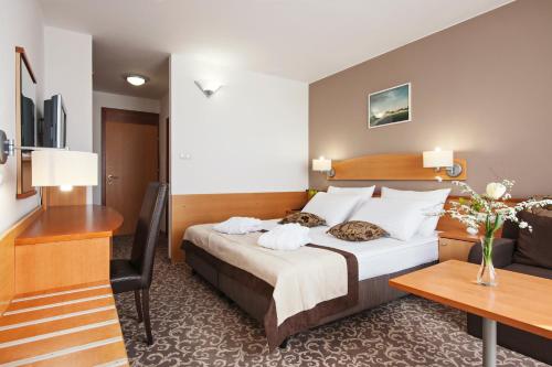 a hotel room with a bed and a desk at Hotel Termal - Terme 3000 - Sava Hotels & Resorts in Moravske Toplice