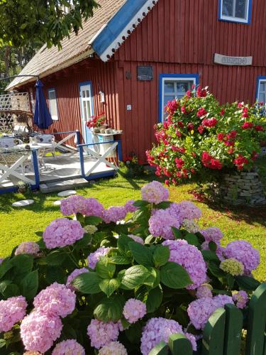 a red house with flowers in front of it at VilaRita in Nida