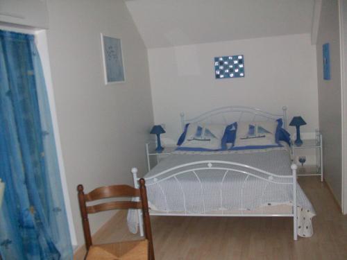 a bedroom with a white crib with blue pillows at Chambres d'Hotes la Belle Taille in Lassay