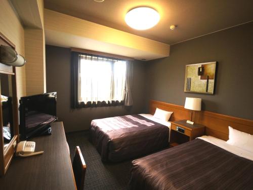 Hotel Route-Inn Nakatsugawa Inter tesisinde bir odada yatak veya yataklar