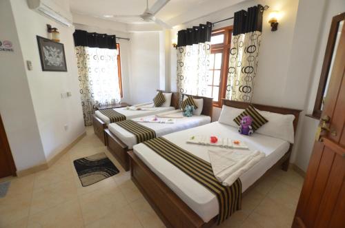 烏達瓦拉維的住宿－塞何羅麗景灣酒店，配有窗户和窗帘的客房内的两张床