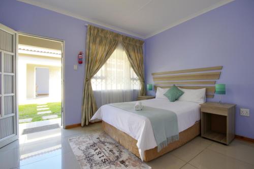 a bedroom with a bed and a large window at Minilitha Lodge in Richards Bay