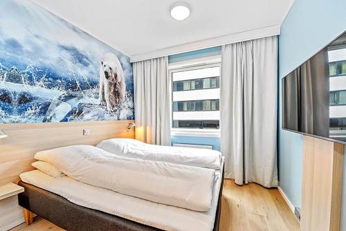 - une chambre avec un lit et une télévision dans l'établissement Thon Hotel Polar, à Tromsø