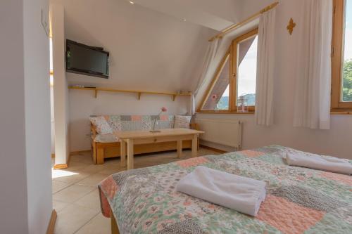 ザコパネにあるRent like home - Orkana IV Centrumのベッド2台、テーブル、テレビが備わる客室です。