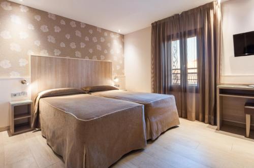 a bedroom with a bed and a piano at Hotel Santa Marta in Barcelona
