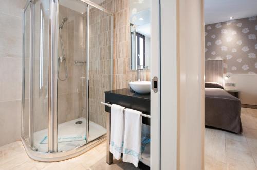 y baño con ducha y lavamanos. en Hotel Santa Marta en Barcelona