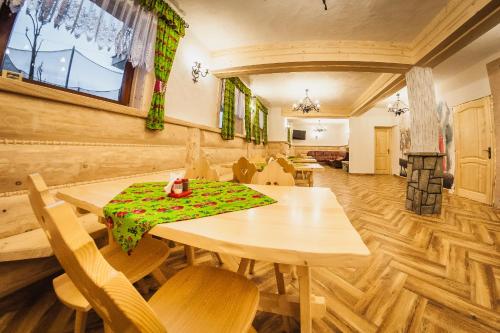 a dining room with a table with a green cloth on it at U Repy in Bańska
