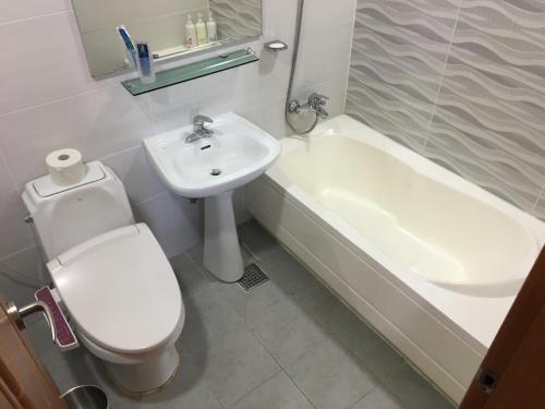 a bathroom with a toilet and a sink and a tub at Sky Motel in Wonju
