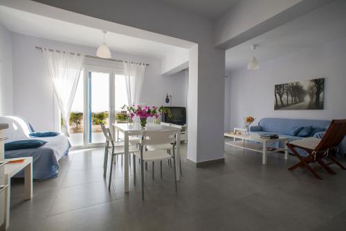 a white living room with a table and a couch at Amfitriti's Apartment in Naxos Chora