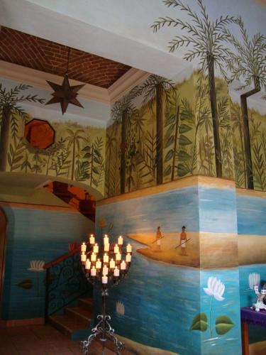 a room with a painting of palm trees on the wall at Hotel Boutique Casa San Angel in Mérida