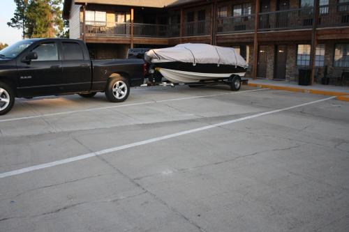 a black truck parked in a parking lot with a boat at Rayburn Inn in Brookeland