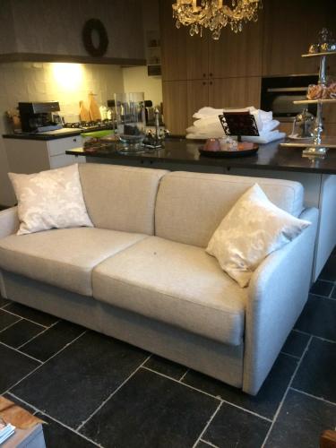 a couch with two pillows sitting in a kitchen at Guestsuite Lady Anna Bruges in Bruges