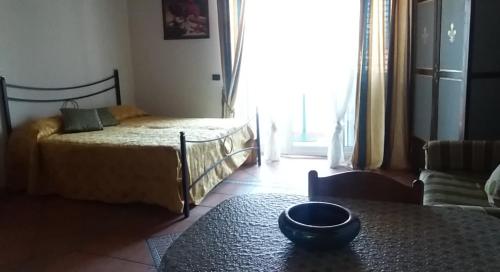 Un dormitorio con una cama y una mesa con un tazón. en Mary home, en SantʼAlessio Siculo