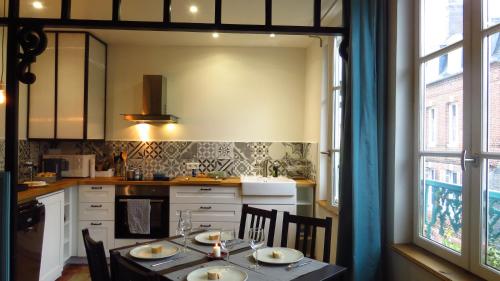 une cuisine avec une table avec des chaises et une salle à manger dans l'établissement Appartement Galerie, à Honfleur