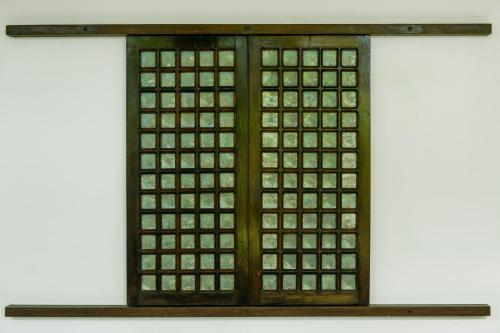 a glass door with a wooden frame on a shelf at Balay Tuko Garden Inn in Puerto Princesa City