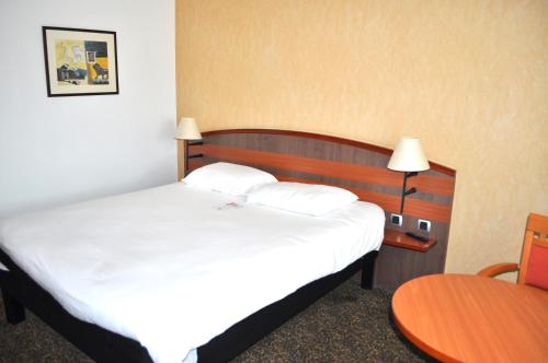 a hotel room with a bed and a table at ibis Belfort Danjoutin in Belfort