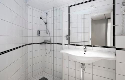 a white bathroom with a sink and a shower at Thon Hotel Vettre in Asker