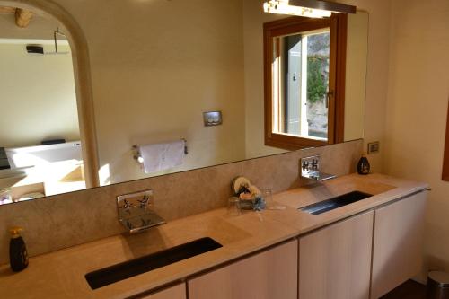a bathroom with two sinks and a large mirror at Casale La Rocchetta in Lonigo