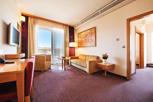 a hotel room with a couch and a table at Grand Hotel Primus - Terme Ptuj - Sava Hotels & Resorts in Ptuj