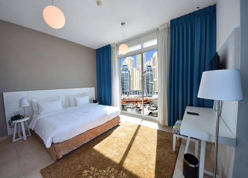 een slaapkamer met een groot bed en een groot raam bij Jannah Place Dubai Marina in Dubai