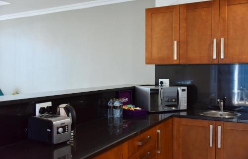 a kitchen with a counter with a microwave and a sink at Jannah Place Dubai Marina in Dubai