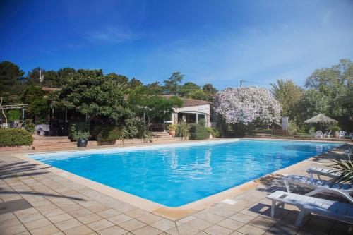 une piscine avec de l'eau bleue dans une cour dans l'établissement Camping Arutoli, à Porto-Vecchio