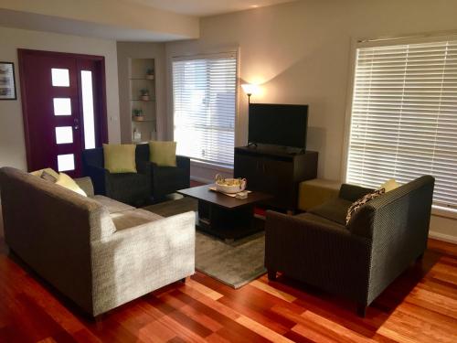 a living room with two chairs and a tv at Encore Apartments in Bathurst