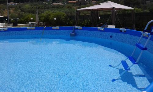 een groot blauw zwembad met twee stoelen erin bij B&B Le Rose in Santa Maria di Castellabate