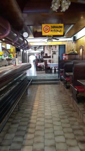 a restaurant with benches and tables in a room at RESTORAN PRENOĆIŠTE CROATIA TURIST in Ðakovo