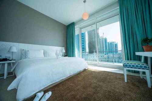 a hotel room with a large bed and a large window at Jannah Place Dubai Marina in Dubai