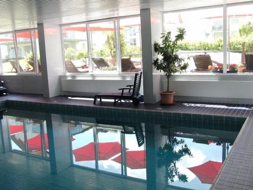 a swimming pool with a chair in a building at Golfhotel Hebelhof in Bad Bellingen