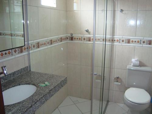 La salle de bains est pourvue de toilettes, d'un lavabo et d'une douche. dans l'établissement Hotel Tubarão, à Natal
