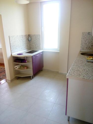 an empty kitchen with a counter and a window at Green Villa Rodna in Skopje