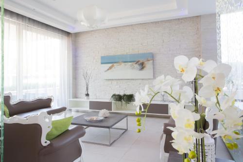 a living room with white furniture and white flowers at Hotel Liberty Beach - Parking & Beach in Riccione